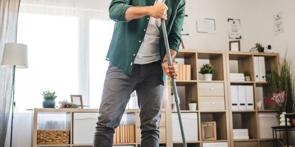 Man mopping bright modern living room
